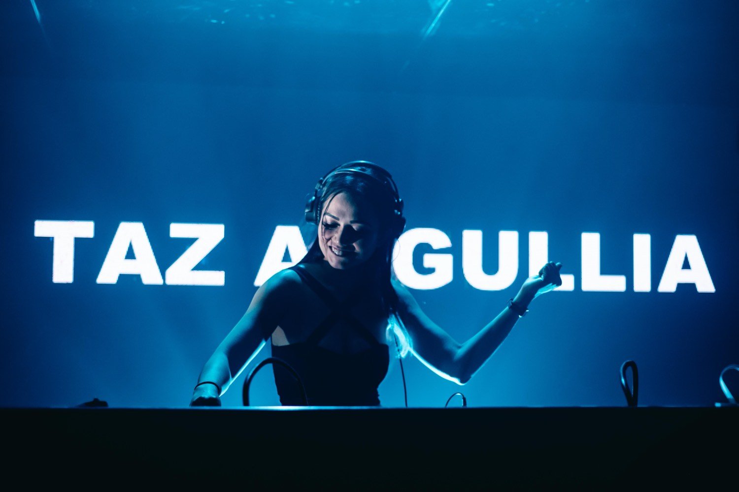 Zouk, Singapore — hands raised in blue stage light, her name on the screen behind